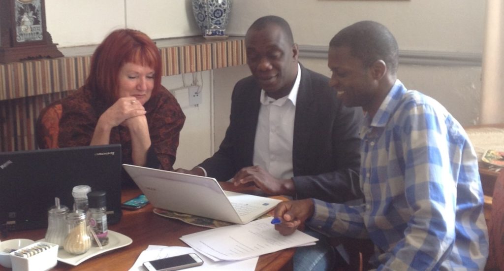 Diana Gibson and members of her Collaborative Working Group sitting around a laptop