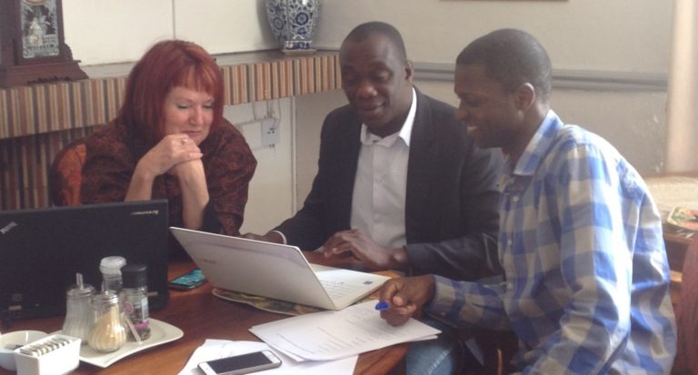 Diana Gibson and members of her Collaborative Working Group sitting around a laptop